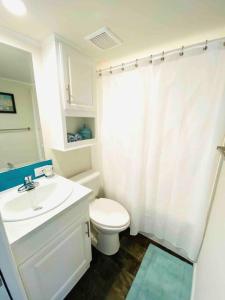 a white bathroom with a toilet and a sink at Vacation Cottage North Myrtle Beach 68 in Myrtle Beach