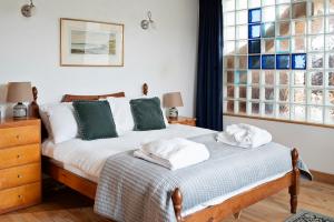 a bedroom with two beds and a window at Beautiful Cornish Home "High on the Cliffs" in Praa Sands