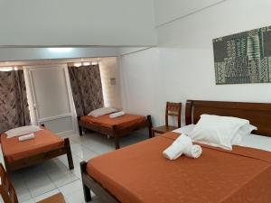 um quarto de hotel com duas camas e duas cadeiras em Hotel Le Rotabas em Sainte-Anne