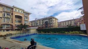 a person taking a picture of a swimming pool with buildings at My Arezzo 1 BR Condo in Davao City