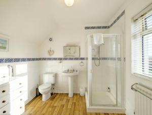 une salle de bain avec toilettes, lavabo et douche dans l'établissement Fishermans Cottage, Felpham, à Felpham 35 autres photos