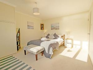 a bedroom with a bed and a bench in it at Fishermans Cottage, Felpham in Felpham