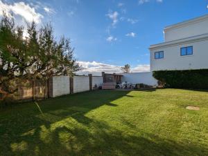 a yard with a fence and a white house at Fishermans Cottage, Felpham in Felpham