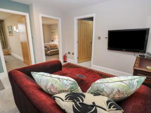 a living room with a red couch and a flat screen tv at New Heights in Keighley