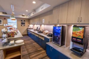 a large kitchen with a snack bar and a video game at TownePlace Suites Columbus Airport Gahanna in Gahanna