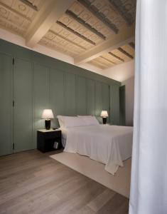 ein Schlafzimmer mit einem großen weißen Bett und zwei Lampen in der Unterkunft Parisii Bocca di Leone 88 in Rom