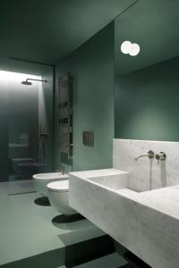 ein Badezimmer mit zwei Waschbecken und einem WC in der Unterkunft Parisii Bocca di Leone 88 in Rom