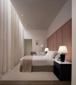 a bedroom with a large bed and curtains at Parisii Bocca di Leone 88 in Rome