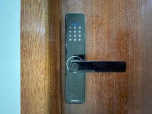 una manija negra en una puerta de madera en The Férias | Suites Luxo, en Cabo Frío