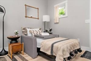 een slaapkamer met een bed, een lamp en een raam bij H Studio Close to Downtown, Beaches and Wineries in Traverse City +40 foto's