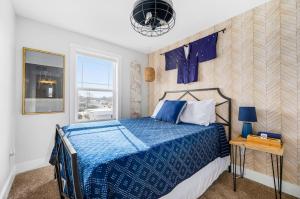 a bedroom with a blue bed and a window at Heiwana 3BR Stand Alone Home Near Beaches and Wineries in Traverse City
