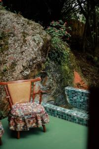 Cattaleya في Yumbo: كرسي خشبي جالس بجانب صخرة