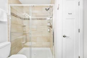 a shower with a glass door in a bathroom at Heiwana 3BR Stand Alone Home Near Beaches and Wineries in Traverse City +86 photos