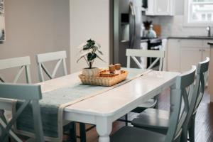 a kitchen table with chairs and a table with a plant on it at Lakescape, Modern 3BD Townhome Near Downtown and Wineries in Traverse City +54 photos