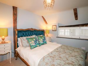 a bedroom with a bed and a chandelier at Peppermint Cottage in Petworth