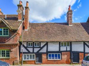 an old house with a clock on the side of it at Peppermint Cottage in Petworth