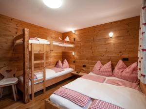 2 Etagenbetten in einem Zimmer mit Holzwänden in der Unterkunft Apartment-Chalet Mödlinghof in Hopfgarten im Brixental