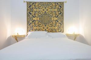 Un dormitorio con una cama blanca con una pared negra y dorada en CASA SEÑORIAL CON PISCINA. CASA DONNA ISABEL en Peñaflor