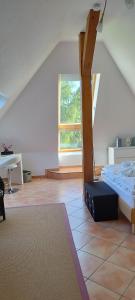 a attic room with a bed and a ladder at Traumblick und Komfort - lichtdurchflutete 85 qm Wohnung nahe Südstrand Göhren inklusive Schwimmbad und Sauna im AHOI Sellin in Göhren