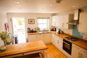 a kitchen with white cabinets and a wooden counter top at 9 Solent Landing in Bembridge