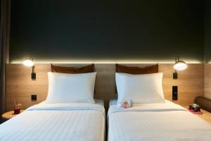 two beds sitting next to each other in a room at Moxy Chester in Chester