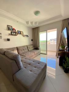 a living room with a couch and a television at Apartamento confortável Ilhéus in Ilhéus