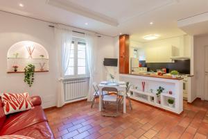 Milvio Bridge - cozy apartment in Rome في روما: غرفة معيشة مع طاولة ومطبخ