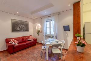 Milvio Bridge - cozy apartment in Rome في روما: غرفة معيشة مع أريكة حمراء وطاولة