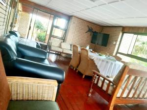 a living room with a table and chairs and a television at Whispering Waves in Van Stadensriviermond