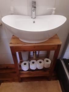 a bathroom with a sink and four rolls of toilet paper at Whispering Waves in Van Stadensriviermond +16 photos