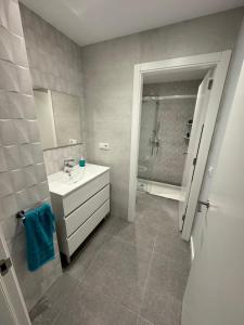 uma casa de banho com um lavatório branco e um chuveiro em BS6 Massanassa 