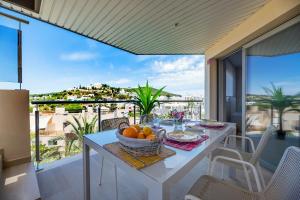 una mesa blanca con un bol de fruta en el balcón en Ático dúplex en Santa Eulalia junto a la playa, en Santa Eulària des Riu