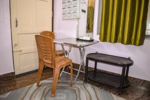 une table et une chaise dans une pièce avec un rideau vert dans l'établissement Green Palace Guest House, à Bānkura