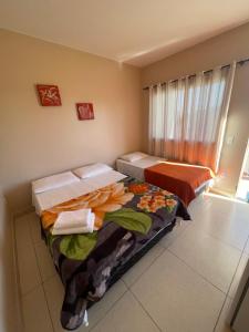a room with two beds and a window at Mirante do Morro in Alto Paraíso de Goiás