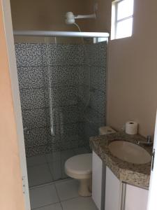 a bathroom with a shower and a toilet and a sink at Mirante do Morro in Alto Paraíso de Goiás