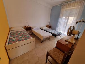 1 dormitorio con 2 camas, escritorio y silla en Casa di Mamma, en Godrano