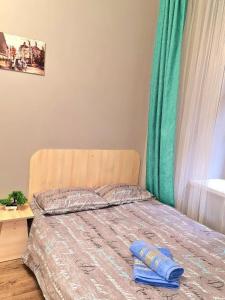 - un lit avec un oreiller bleu et un rideau vert dans l'établissement Студіо Філатова 8, à Lviv