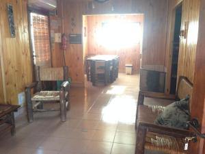 una habitación con paredes de madera y una habitación con sillas en Cabañas Viña Aliwen en Vistalba