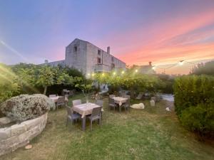 ogród ze stołami i krzesłami przed budynkiem w obiekcie Agriturismo La Palascìa Masseria Agreste w mieście Otranto