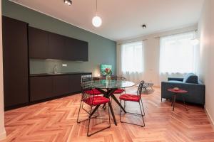 een keuken en een woonkamer met een tafel en stoelen bij Roma Luxe Suite in Turijn
