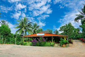 a store on the beach with flowers and palm trees at CoffeeINN Homestay - Jeep Ride, Water Activities, Home Food in Sakleshpur