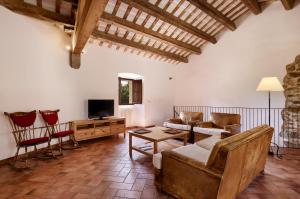 a living room with a couch and a tv at Masia Torre Lloreta S.XIII in Calonge