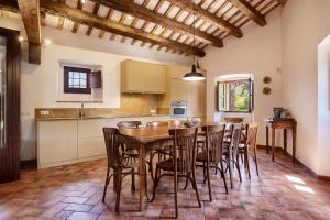 eine Küche und ein Esszimmer mit einem Holztisch und Stühlen in der Unterkunft Masia Torre Lloreta S.XIII in Calonge