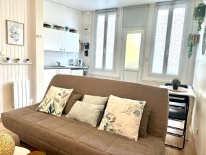 un soggiorno con un divano marrone e una cucina di Studio, Sea and the Beach a Le Havre Altre 17 foto