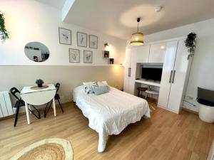 a bedroom with a bed and a table and a television at Studio, Sea and the Beach in Le Havre