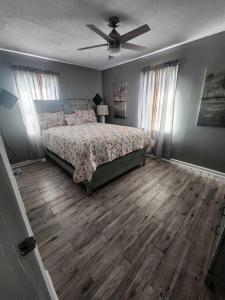 Schlafzimmer mit einem Bett und einem Deckenventilator in der Unterkunft X Marks the Spot. 