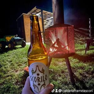 a person holding a bottle of beer next to a traffic light at Cabana Frame A Scorilo in Poiana Mărului