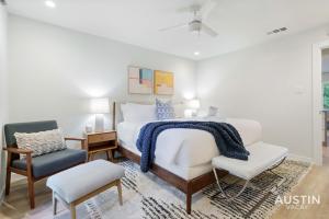 a white bedroom with a bed and a chair at Close to Barton Springs and Zilker w King BR and Patio in Austin