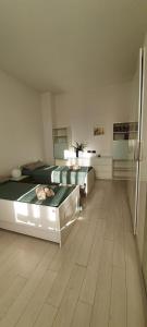 1 dormitorio grande con 2 camas y suelo de madera en Intero Appartamento LGBTQ+ zona Loreto, en Milán