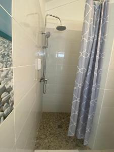 een douche met een douchegordijn in de badkamer bij Hotel Le Rotabas in Sainte-Anne